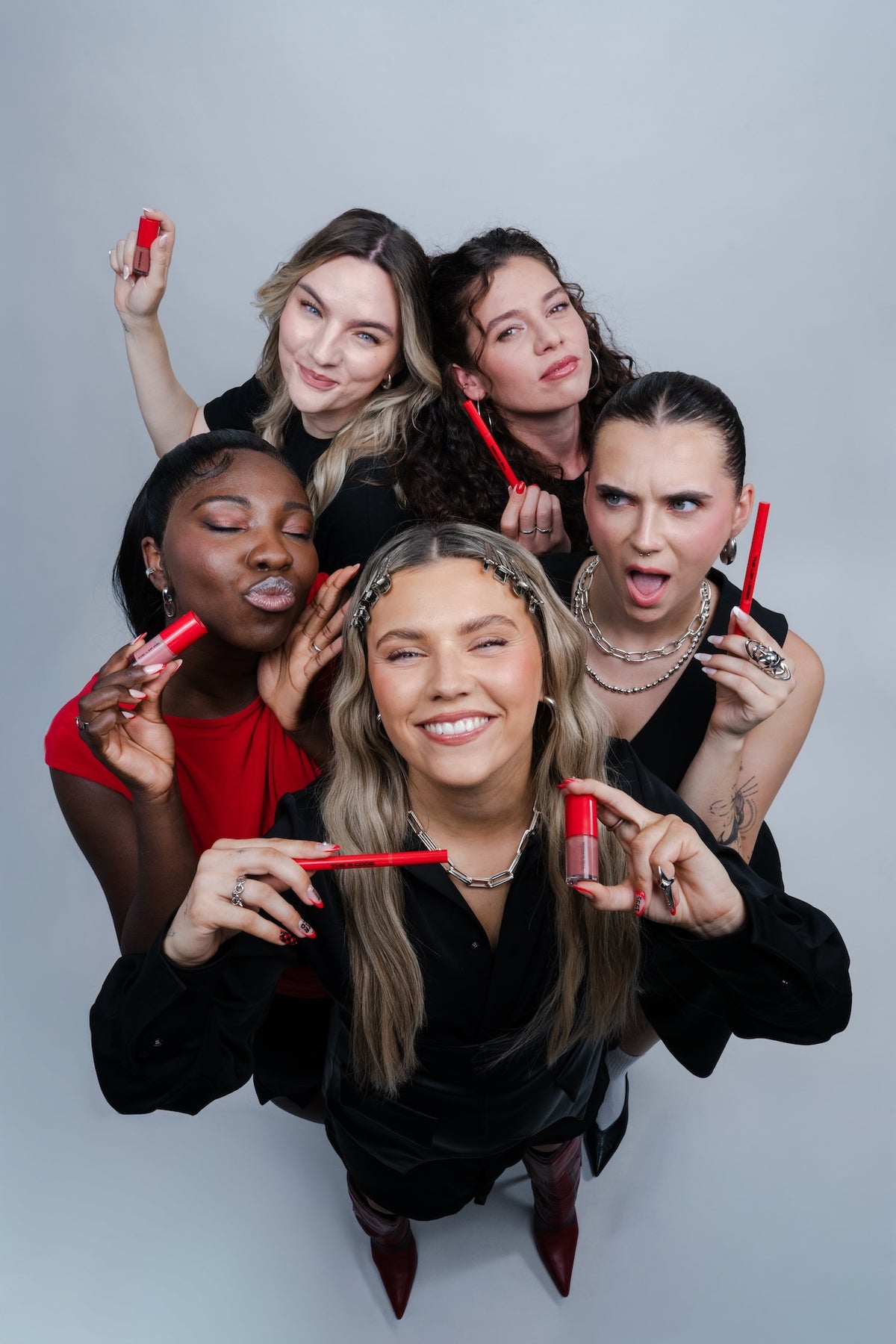Fünf Frauen halten Produkte von TRCD in die Kamera